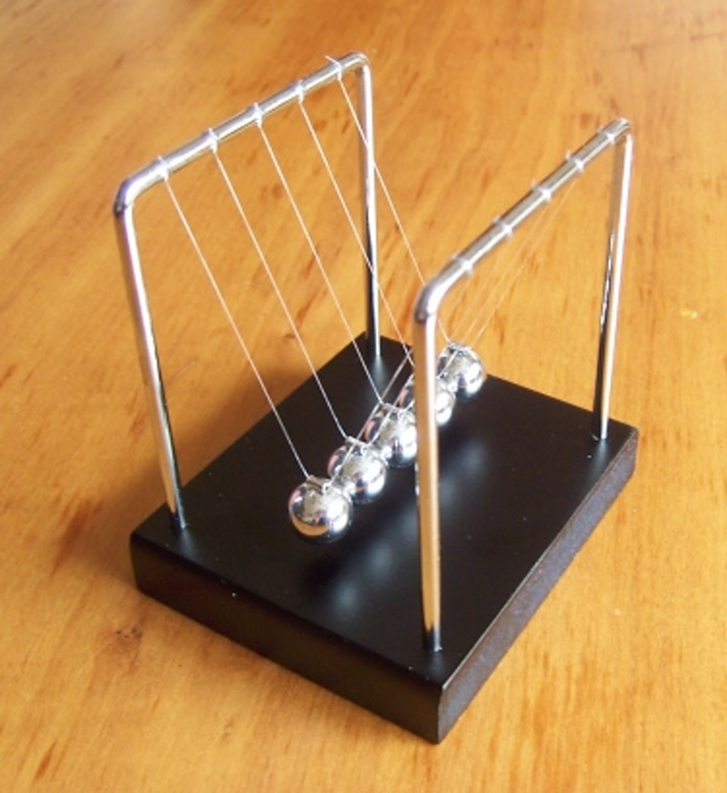 Pendulum Newton, 9 Maret 2008. Foto alat demonstrasi, bukan data eksperimen atau bukti tumbukan ideal; berkas diubah ukuran dan dikonversi ke JPEG.