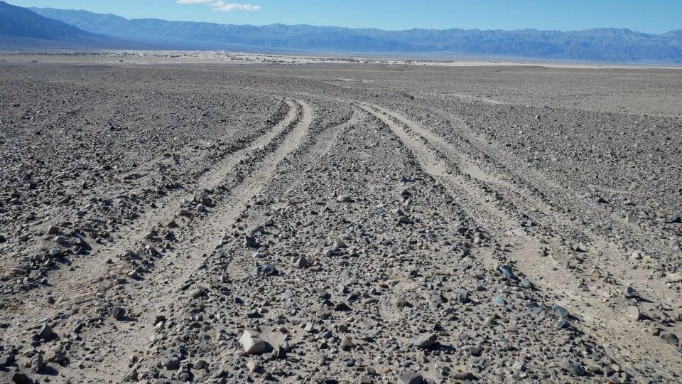 Jejak ban pada desert pavement di Death Valley sebelum pemulihan, dokumentasi NPS. Tanggal pemotretan tidak dirinci; halaman diperbarui 16 Februari 2023. Bukan dokumentasi kondisi hari ini.