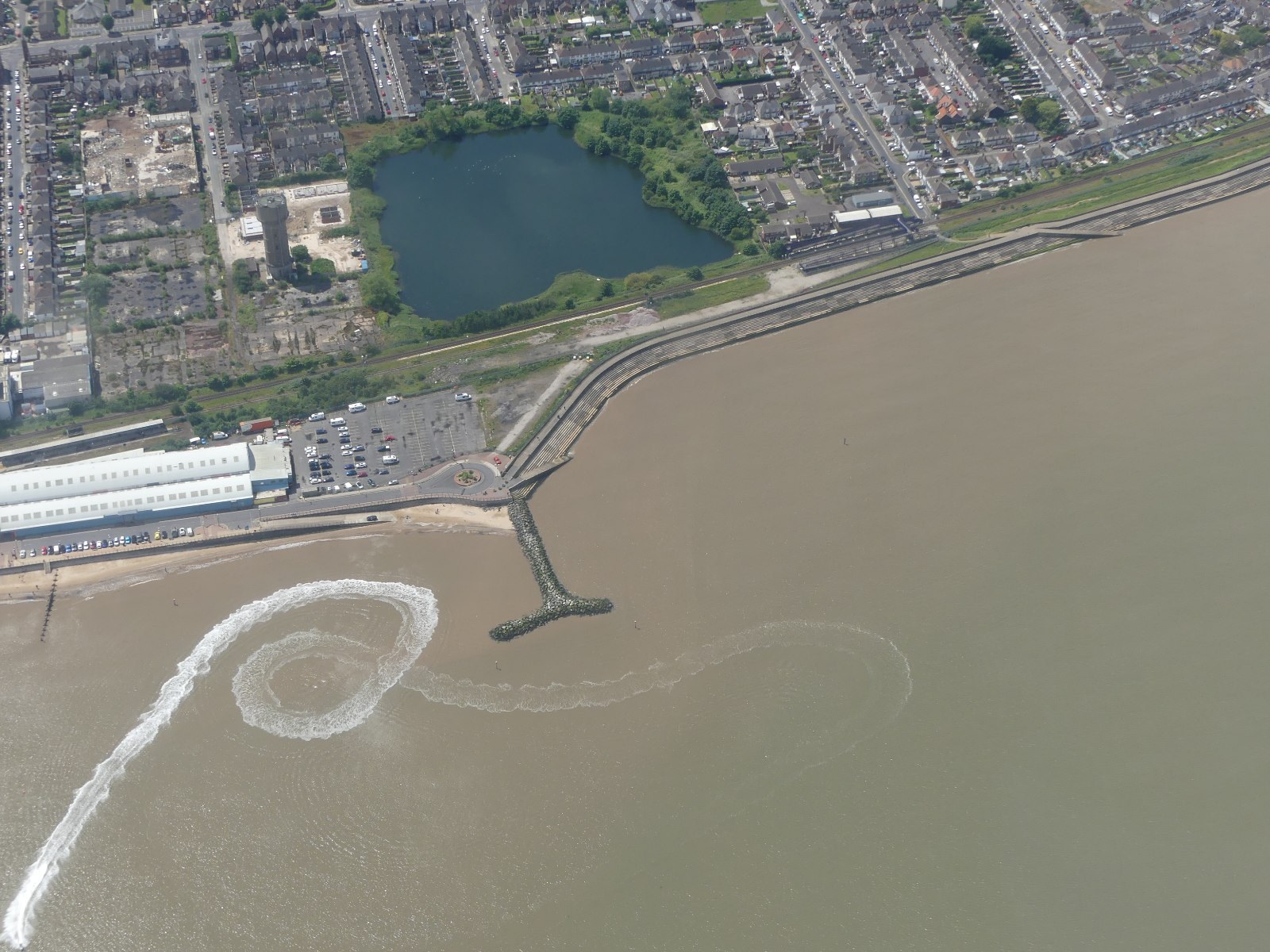 Jejak perahu cepat dilihat dari udara di North Promenade, Cleethorpes, Inggris, didokumentasikan 16 Juni 2024. Foto ilustrasi jejak kapal; bukan pengukuran presisi sudut Kelvin.