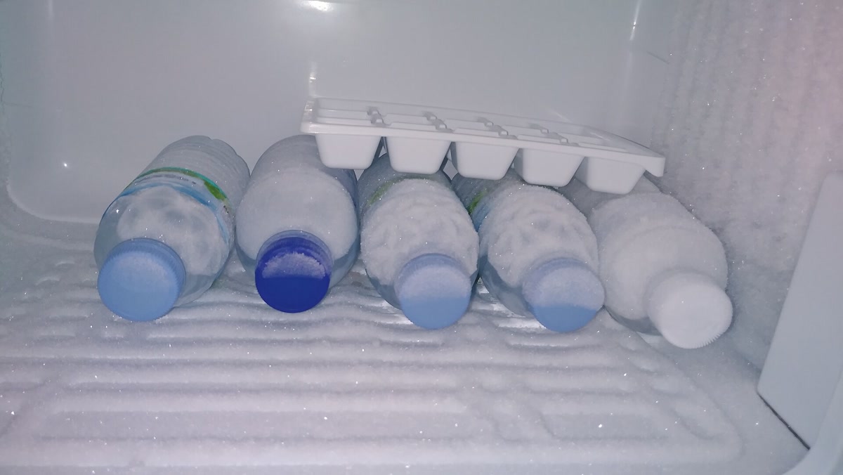 Botol air dan baki es di dalam lemari pembeku, 22 November 2025; foto ilustrasi, bukan eksperimen efek Mpemba. Foto: Philsacor/Wikimedia Commons, CC0; dipotong dan diubah ukurannya.